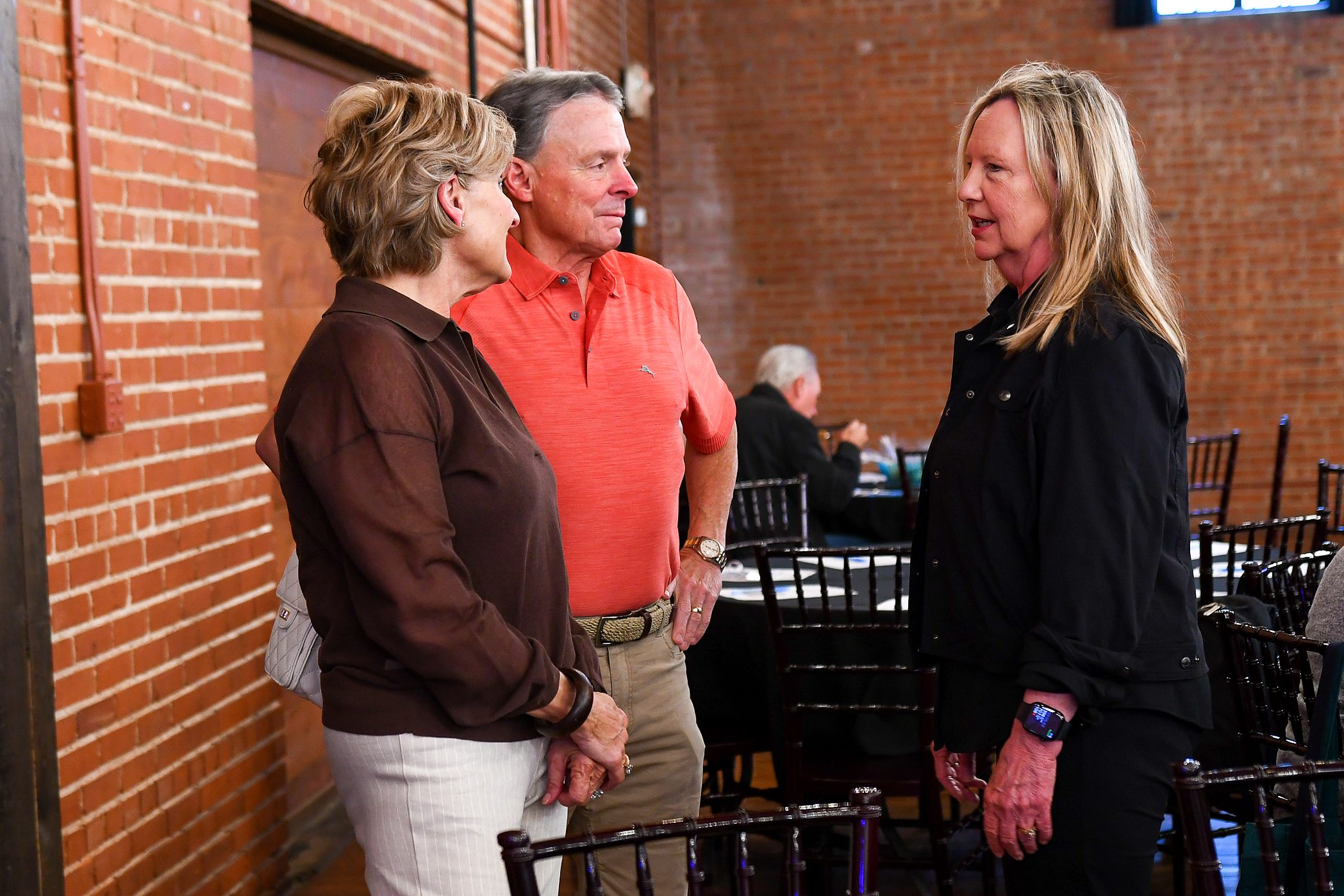 Guests talking by the brick wall at the firm's 2026 annual client meeting